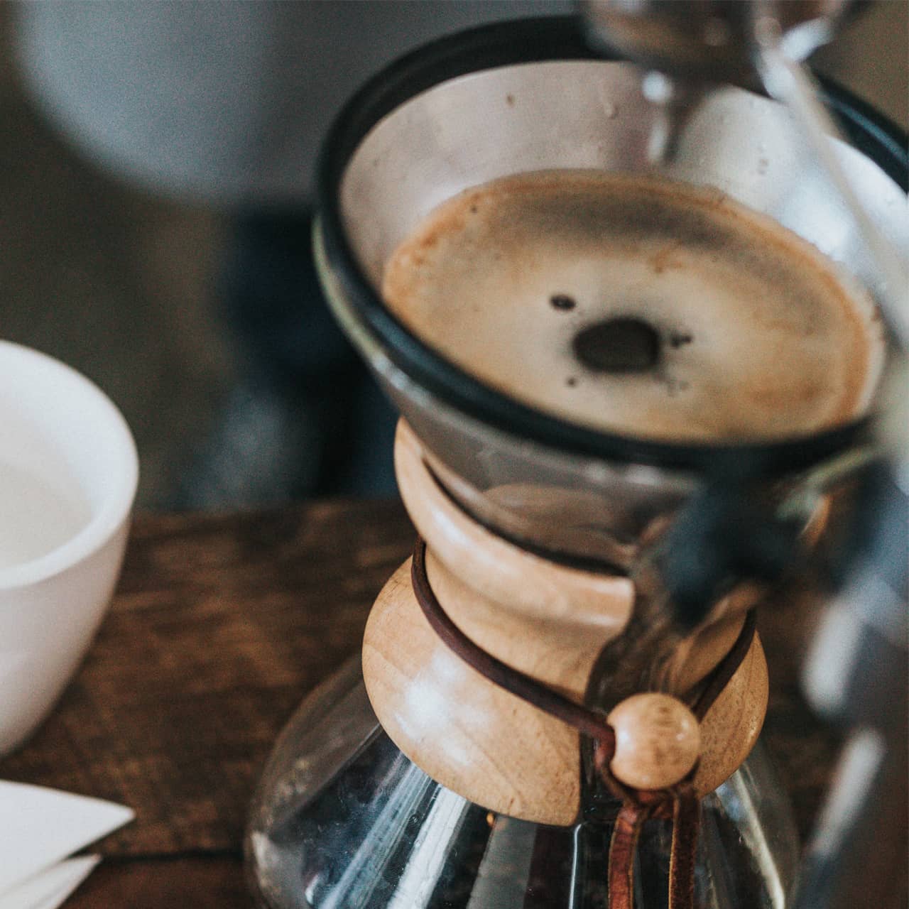 a glass coffee maker with a brown foamy surface